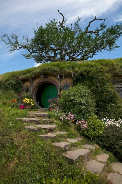 A picturesque hobbit hole set in lush greenery, capturing the charm of the Shire.