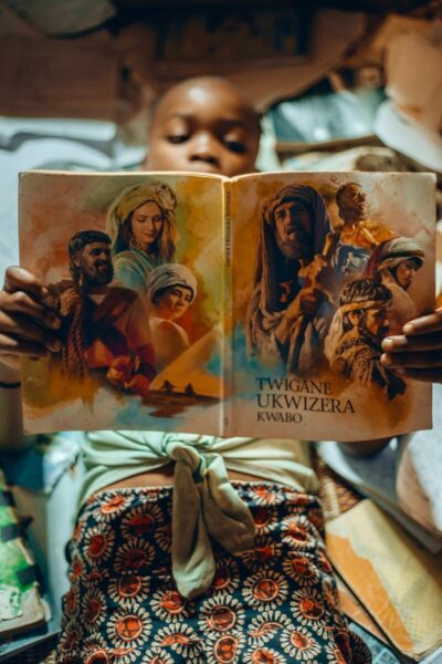 A child relaxing while reading an illustrated book with cultural themes.