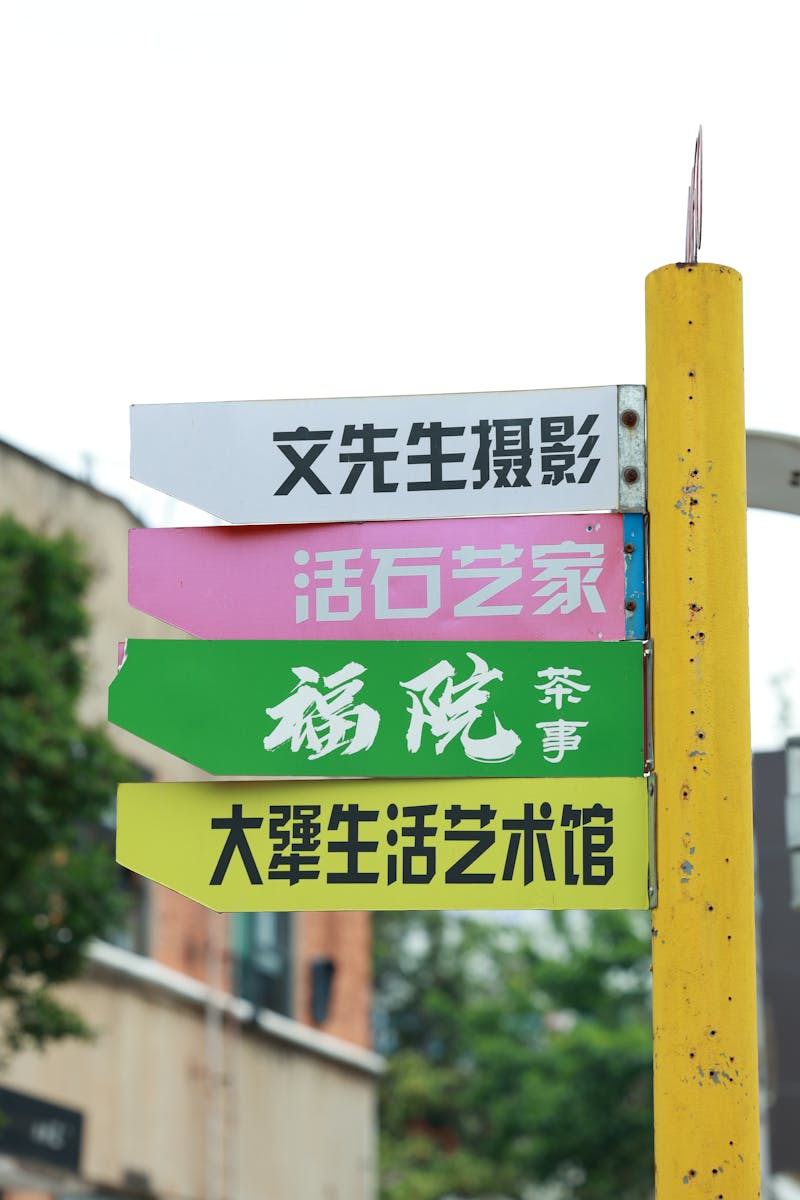 Bright directional sign with Chinese text in urban setting, offering copyspace.