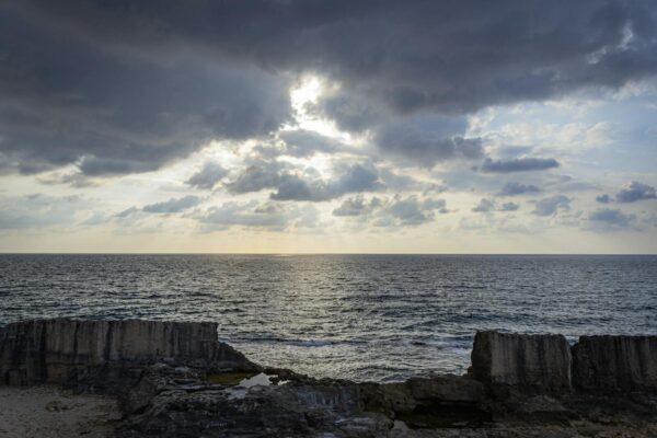Dramatic clouds over the Mediterranean Sea and Phoenician wall in Batroun, Lebanon during sunset.