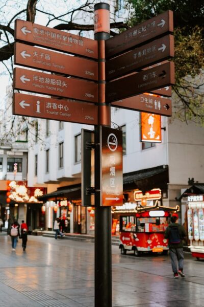 Street scene in Nanjing, China featuring a detailed signpost and vibrant urban life.