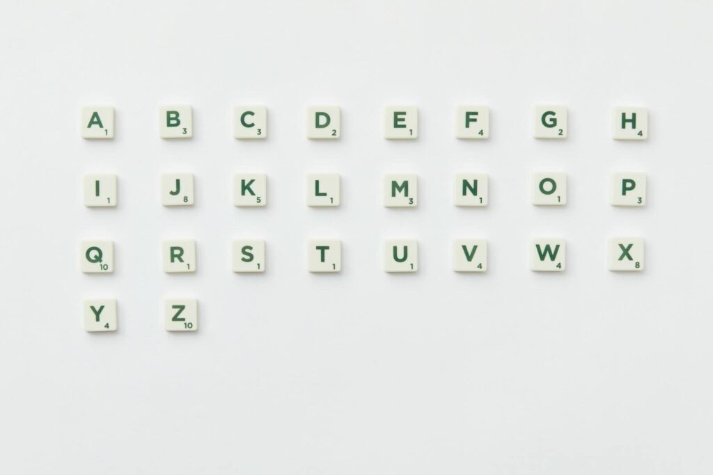 Scrabble tiles arranged alphabetically on a clean white background in a top view layout.