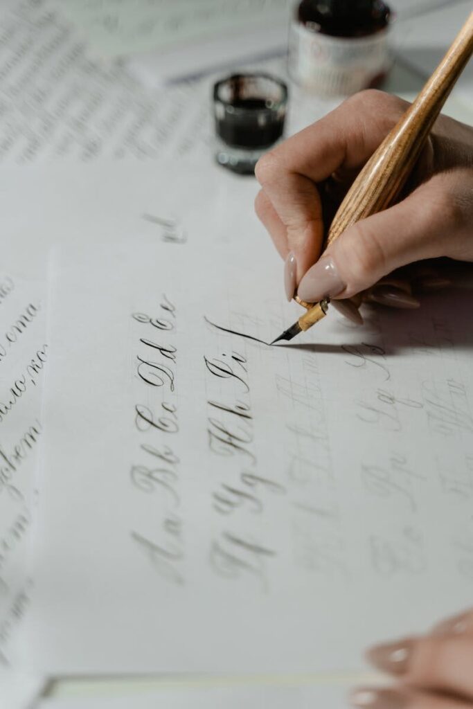 Close-up of practicing elegant calligraphy with ink pen on paper.