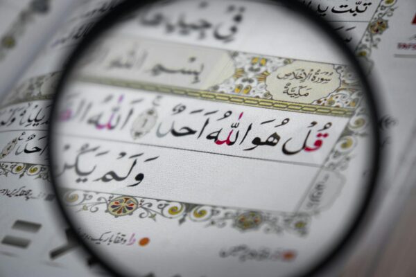 Detailed view of the Quran with intricate Arabic scripts, magnifying religious text and design.